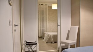 Ein Hotelzimmer mit einem Bett, einem Sessel und einem durchgegangenen Tür sichtbaren Badezimmer.
