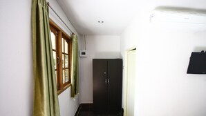 A hallway with a window, a door, and a wall-mounted air conditioner. - Areeya Resort (Sa Kaeo)