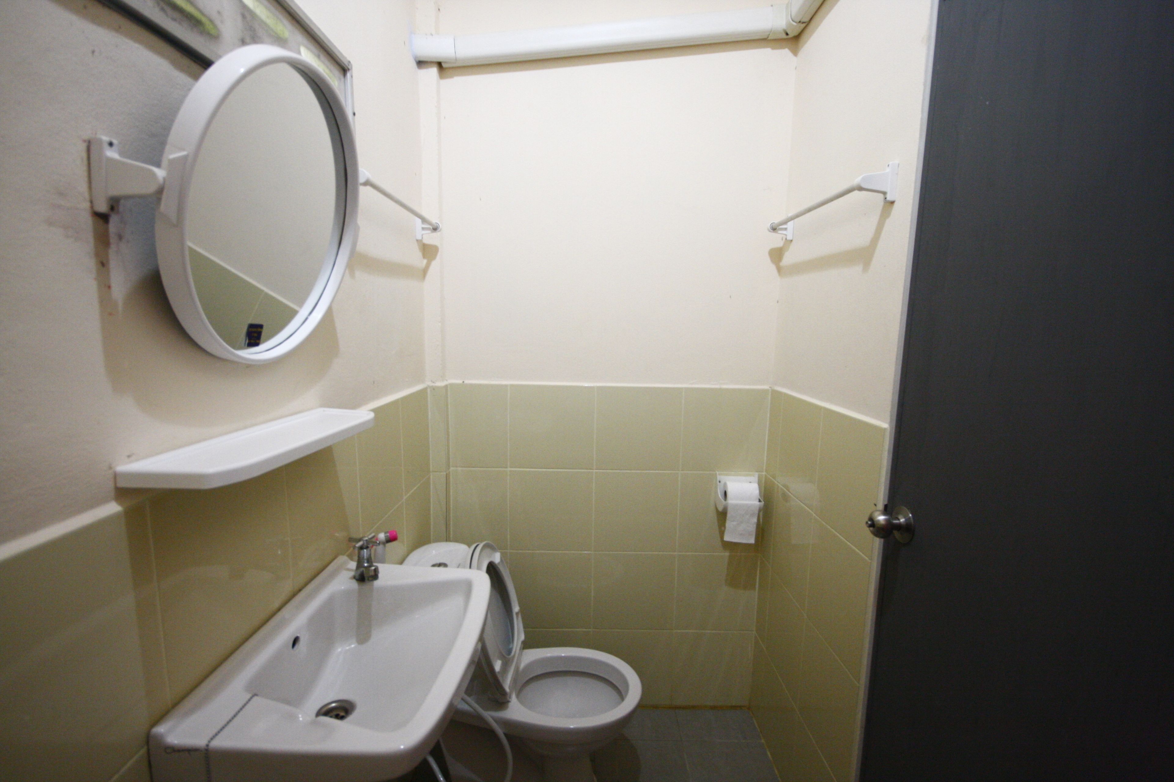 A small bathroom with a sink, toilet, and mirror.