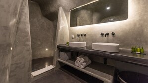Ein modernes Badezimmer mit zwei Waschbecken, einem großen Spiegel und einer Duschkabine.