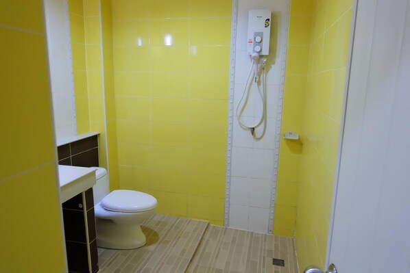 A small bathroom with a toilet, a shower, and a sink. - Sakaeogarden Hotel (Sa Kaeo)