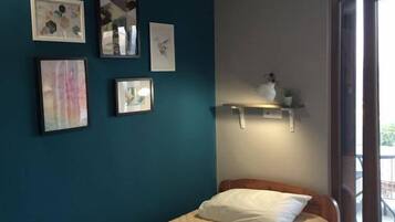 A bedroom with a bed, a window, and wall-mounted shelves.
