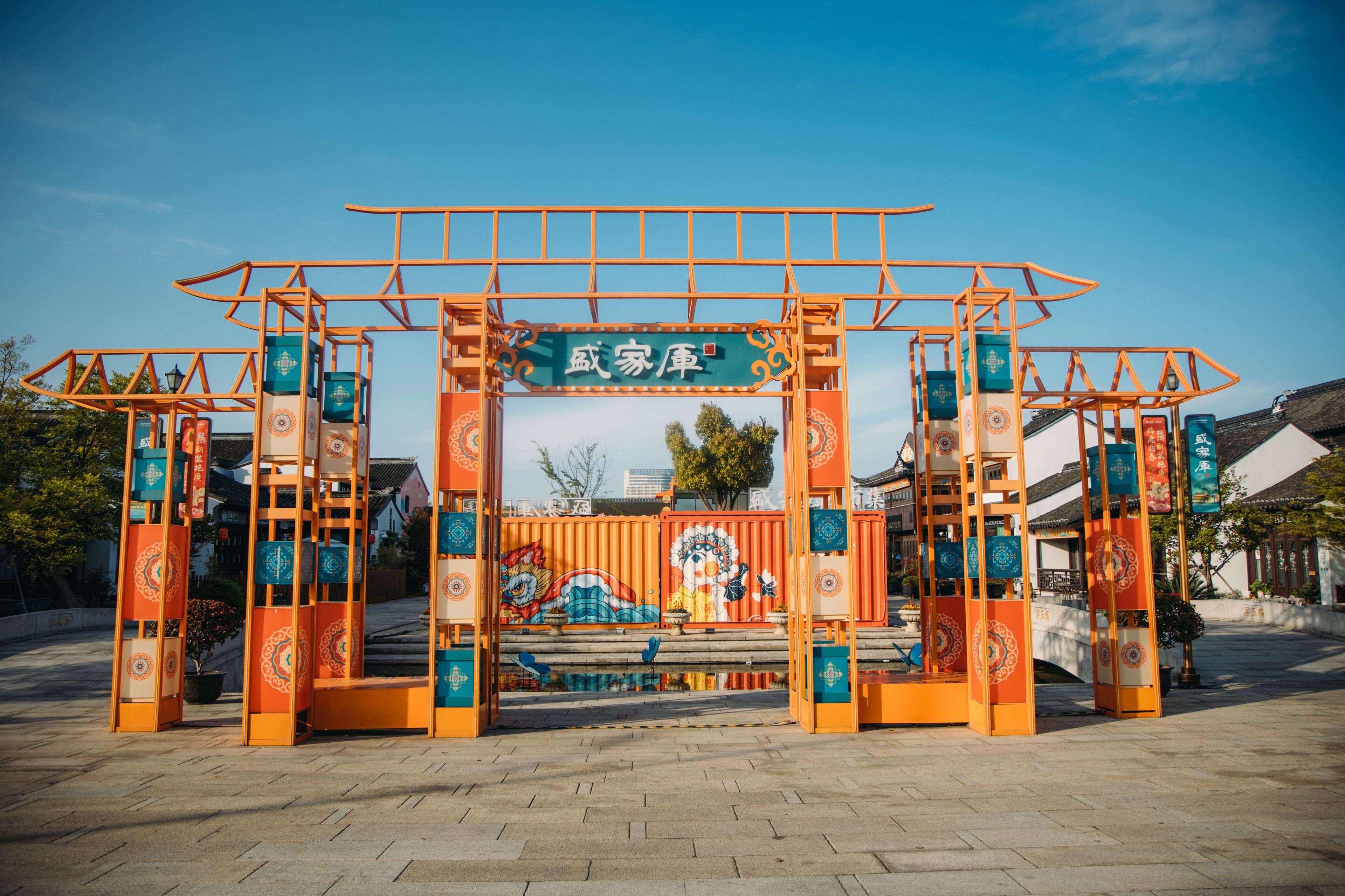 Una entrada con elementos arquitectónicos tradicionales chinos y un cartel con caracteres chinos.
