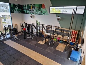 Un gimnasio con diversos equipos de ejercicio, incluyendo máquinas de pesas y pesas libres.