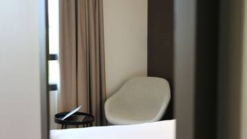 Une chambre d’hôtel avec un lit, une chaise et une petite table sur laquelle se trouve un ordinateur portable.