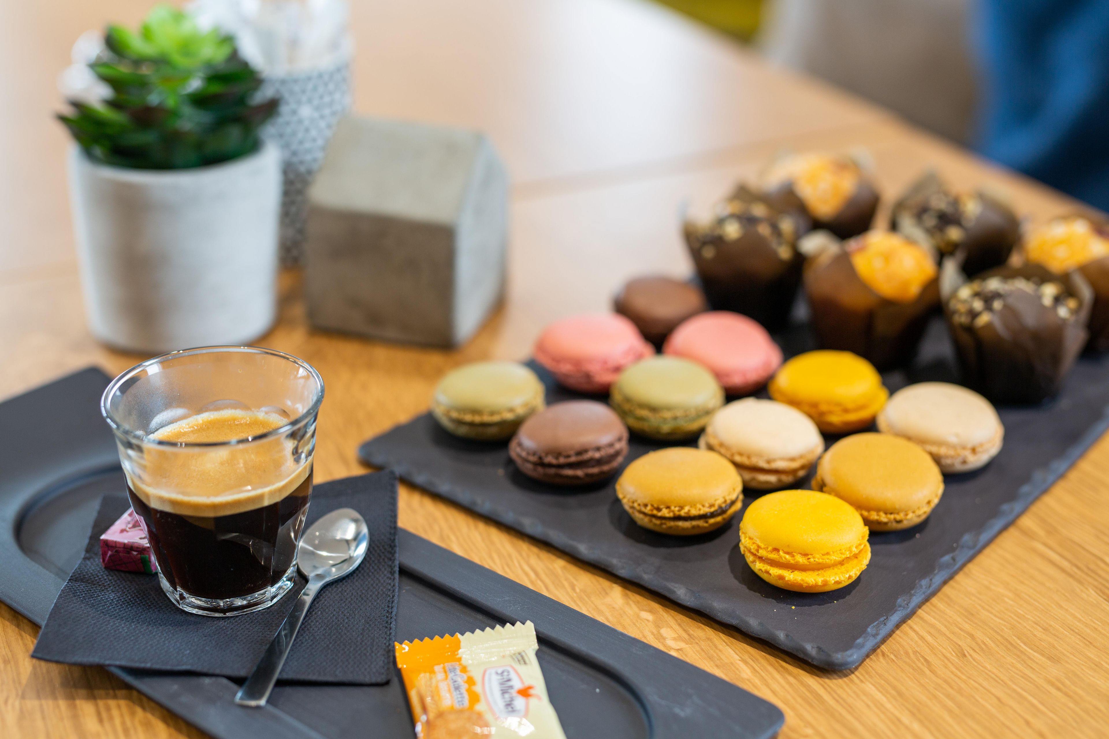 A table with a glass of dark liquid, possibly coffee, and a packet of snacks.