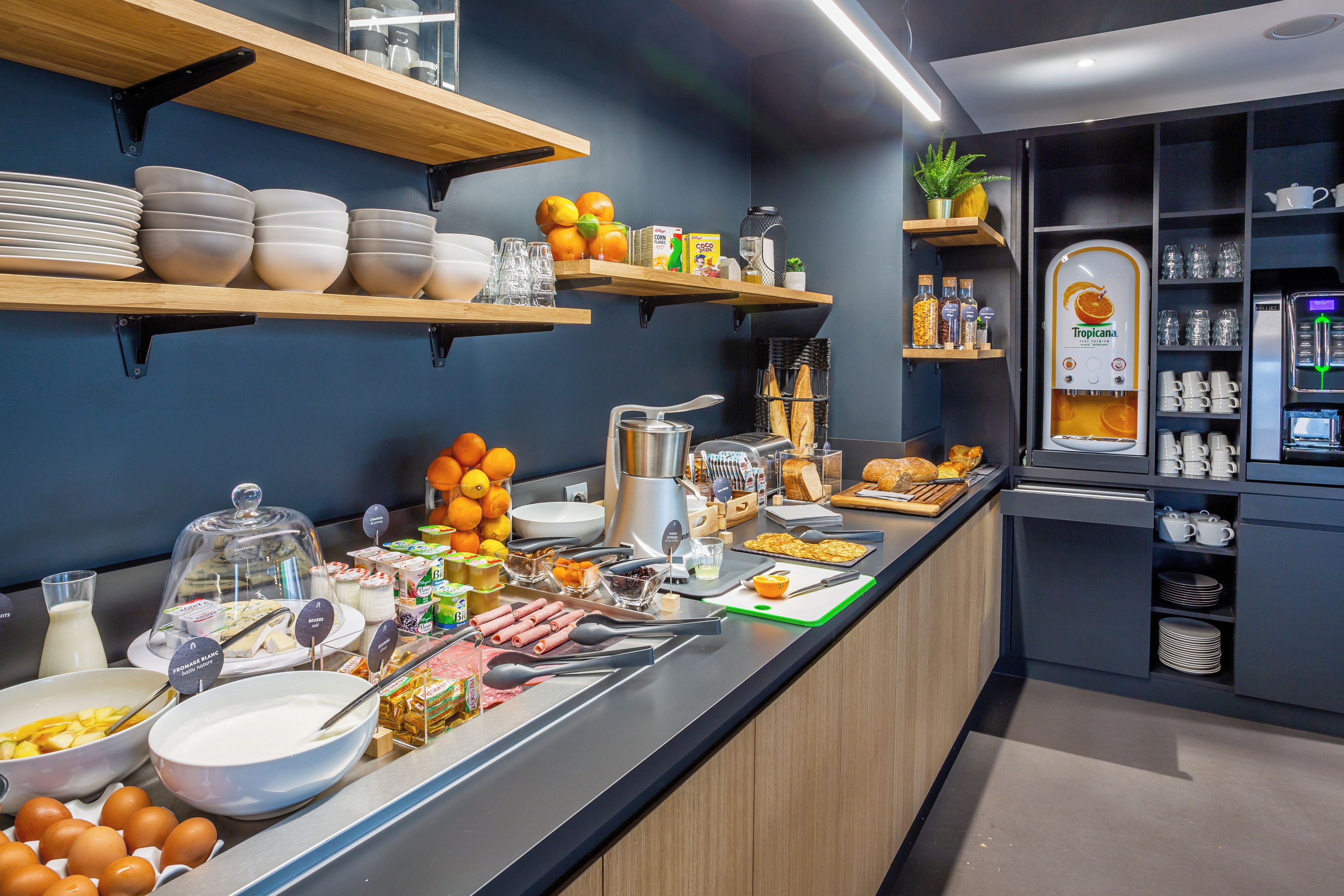 Een ontbijtbuffet met diverse etenswaren, keukengerei en een koffieapparaat.