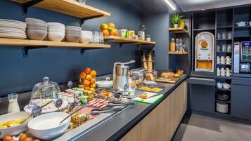 Een ontbijtbuffet met diverse etenswaren, keukengerei en een koffieapparaat.