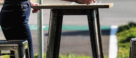 Una persona sistema bicchieri su un tavolo all'aperto.
