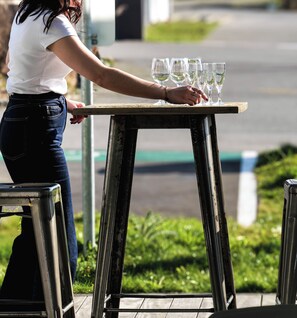 Una persona organizando vasos sobre una mesa al aire libre.