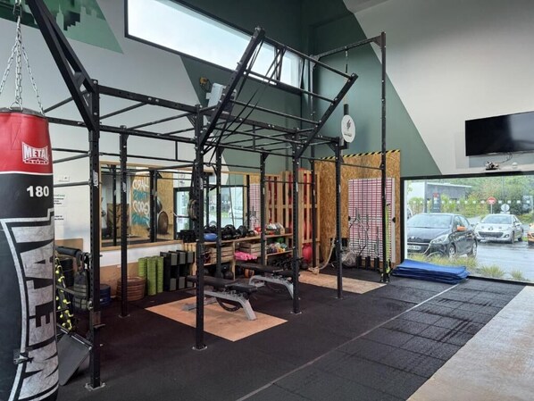 Un gimnasio con una estructura para sentadillas, bancos y un saco de boxeo.