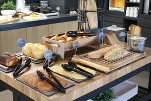 A buffet counter with various baked goods and breakfast items.