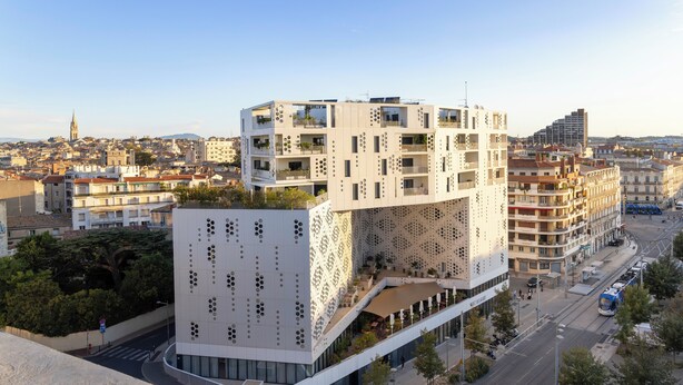 A modern building with a unique geometric facade, multiple balconies, and a rooftop terrace. - Campanile PRIME - Montpellier Centre St Roch (Montpellier)