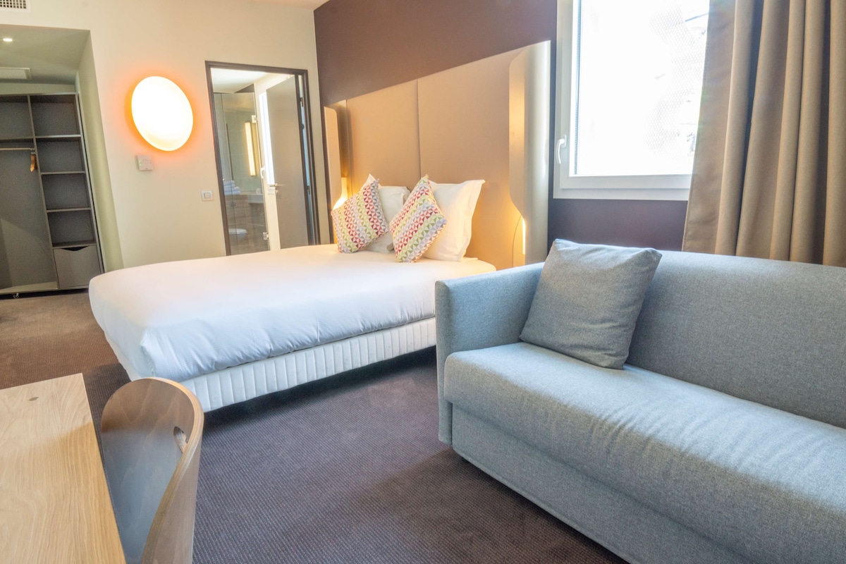 Habitación estándar, 1 cama matrimonial y sofá cama | Ropa de cama de alta calidad, escritorio y cortinas blackout