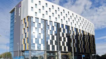 A modern building with a glass facade, multiple windows, and a sign indicating 'Tomorrow Hotel.'