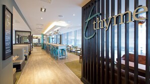 A modern hotel lobby with a bar area, seating, and a large sign reading 'Ethyme.' - Premier Inn Manchester Salford Media City (Salford)