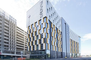 A modern building with a grid-like facade, large windows, and a prominent sign. - Premier Inn Manchester Salford Media City (Salford)