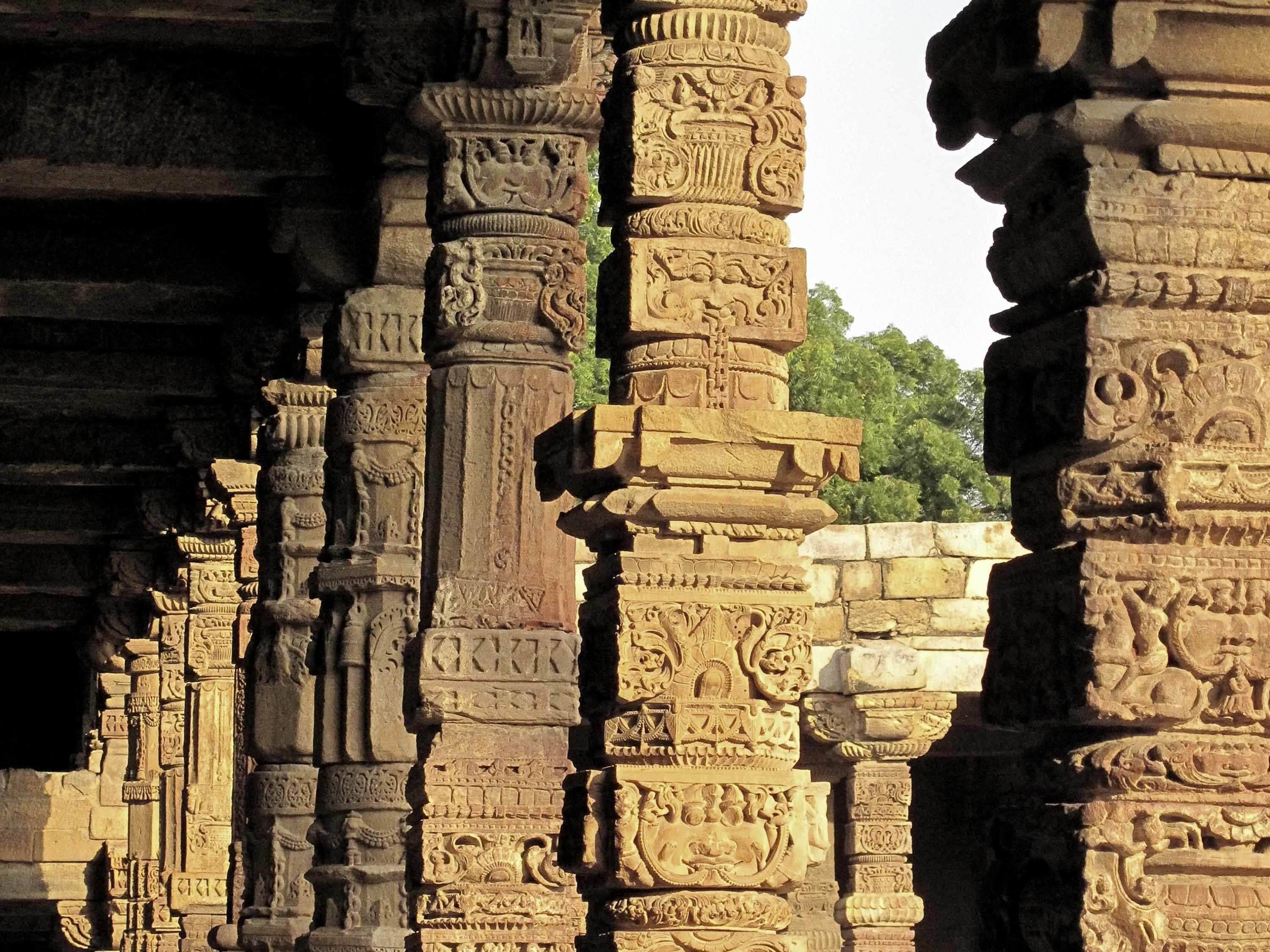 Antiguas columnas de piedra con intrincados grabados, probablemente parte de una estructura histórica.