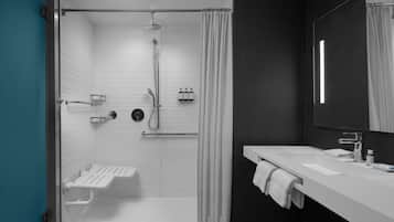 A modern bathroom with a shower, a sink, and a mirror.