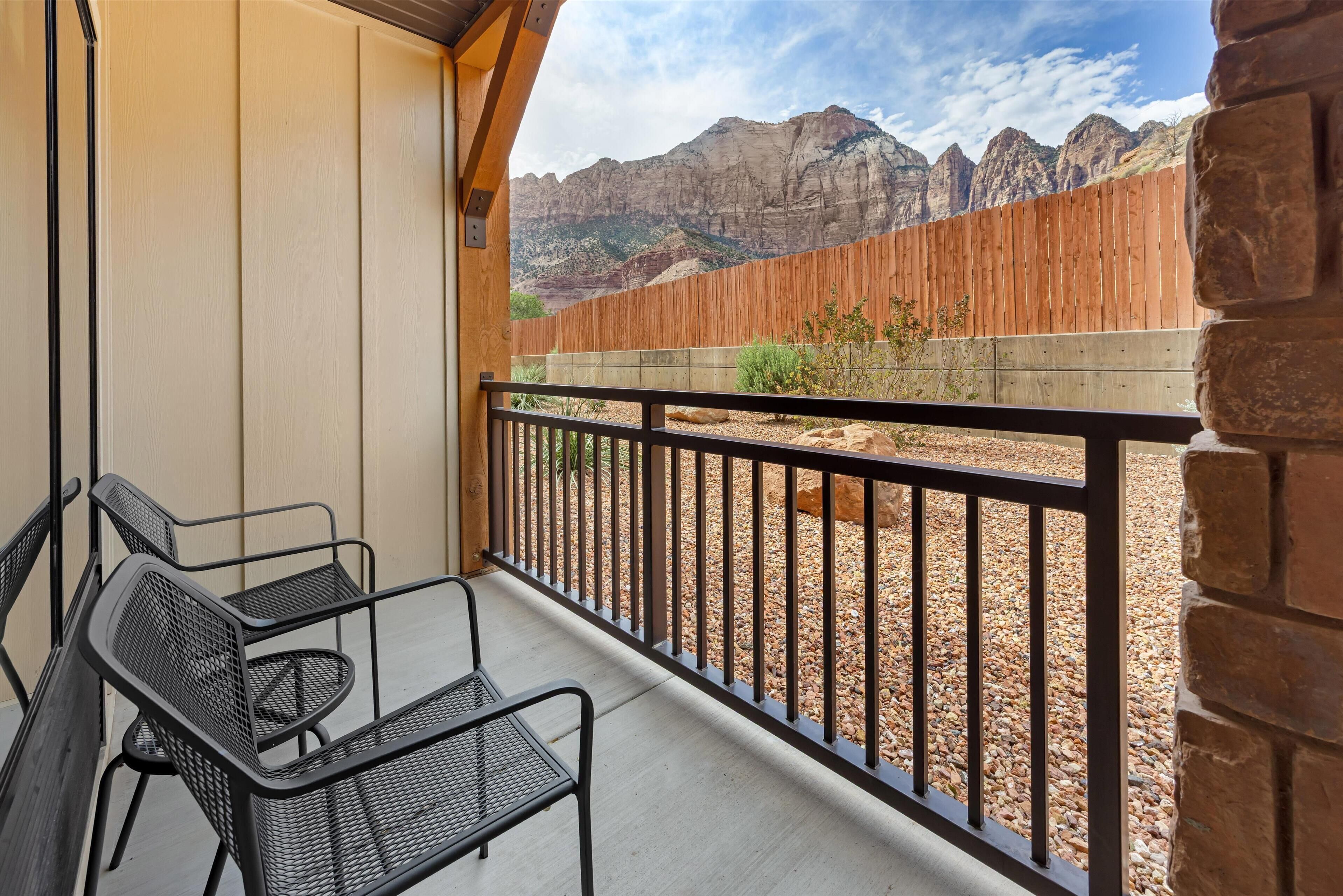 Ein Balkon mit Blick auf einen Holenzaun und Berge.