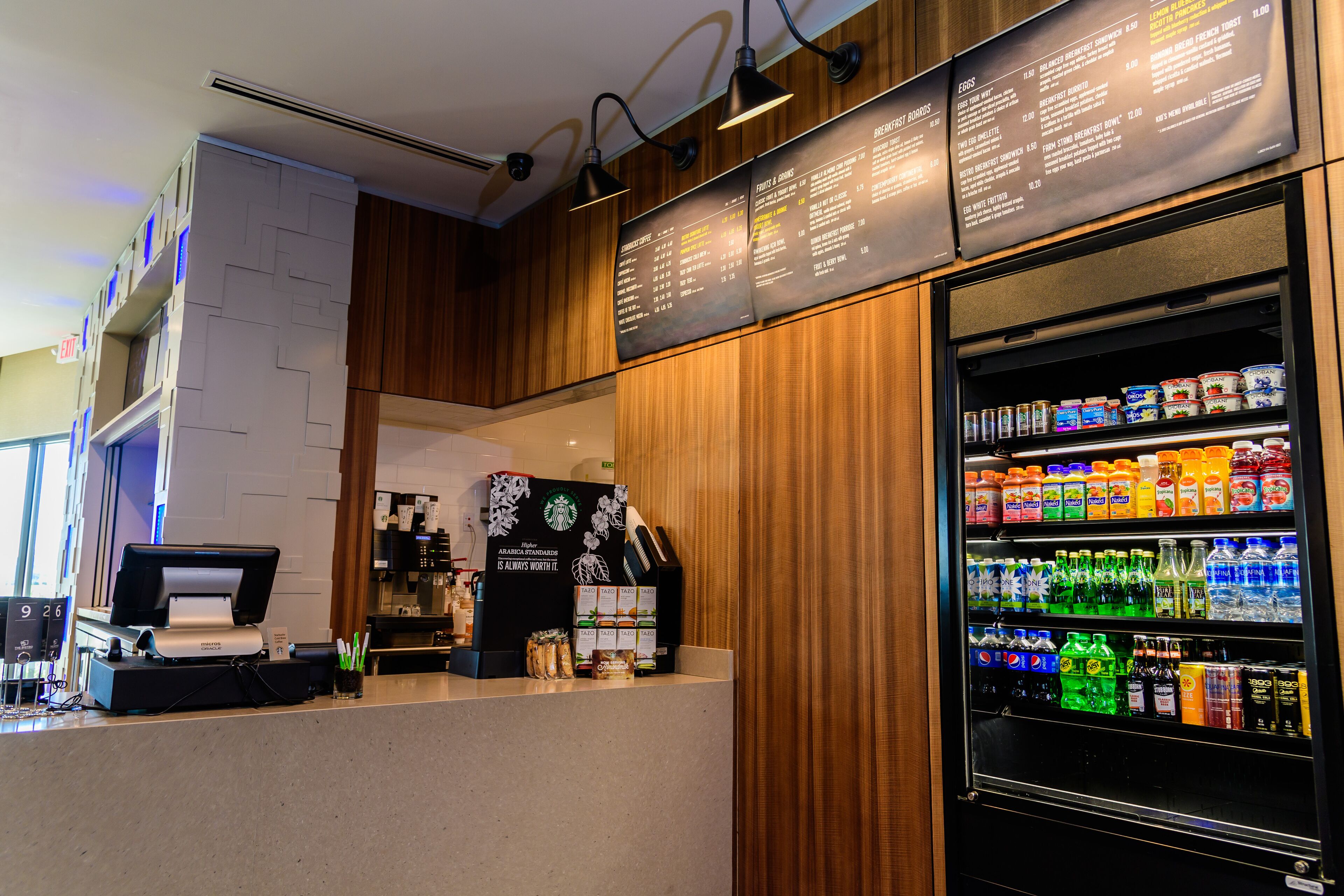 A self-service kiosk with a coffee machine, a menu board, and a beverage dispenser.