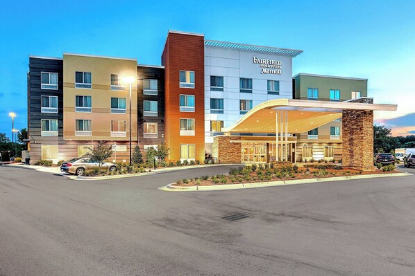 A multi-story hotel with a modern design, featuring a prominent entrance with a glass facade and a stone accent wall. - Fairfield Inn & Suites by Marriott Greenville (Greenville)