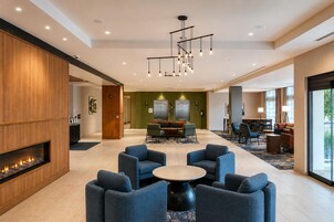 Un hall de hotel con chimenea, zona de estar y comedor.