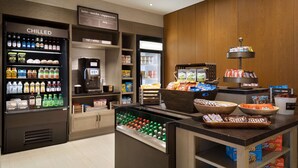 A self-service beverage station with chilled drinks, a coffee machine, and a variety of snacks and desserts. - Hilton Garden Inn Newtown Square Radnor (Newtown Square)