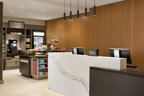 A modern hotel reception area with a marble counter, a coffee machine, and a self-service beverage dispenser. - Hilton Garden Inn Newtown Square Radnor (Newtown Square)
