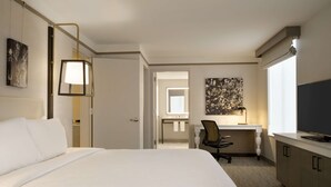 A hotel room with a large bed, a desk with a chair, a television, and artwork on the walls. - Hilton Garden Inn Newtown Square Radnor (Newtown Square)