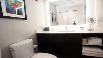 A bathroom with a toilet, sink, and a mirror.