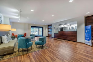 Welcome to our hotel lobby, featuring a spacious reception area with a digital display and comfortable seating.