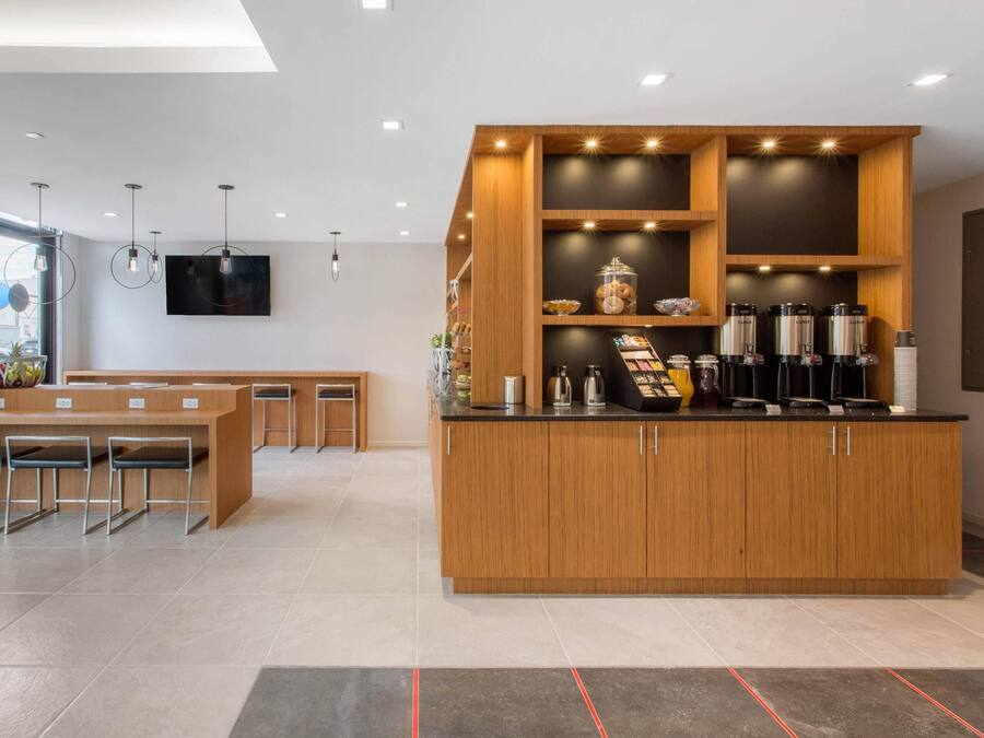 Une cuisine moderne dotée d’un îlot central, d’appareils électroménagers intégrés et d’un coin repas avec des chaises.