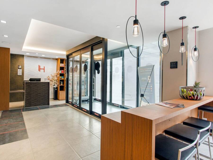 Eine moderne Hotelhalle mit einer Rezeption, einer Lounge und großen Fenstern mit Blick.