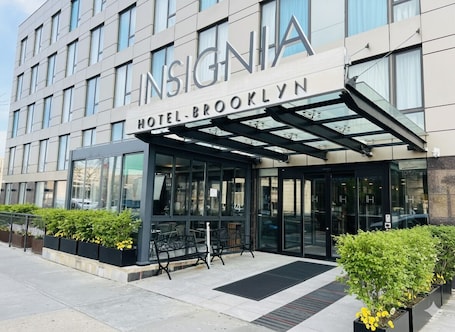 Hotel Brooklyn's exterior with a modern design, large windows, and a covered entrance area.