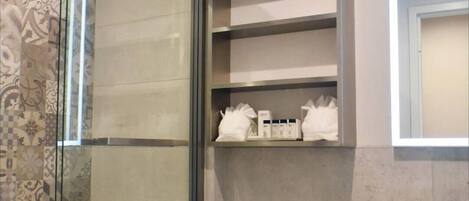 Une salle de bain moderne avec une douche à parois de verre, des toilettes et un meuble-lavabo avec un miroir.