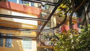 Un edificio de varios niveles con balcones, una escalera y plantas en macetas.