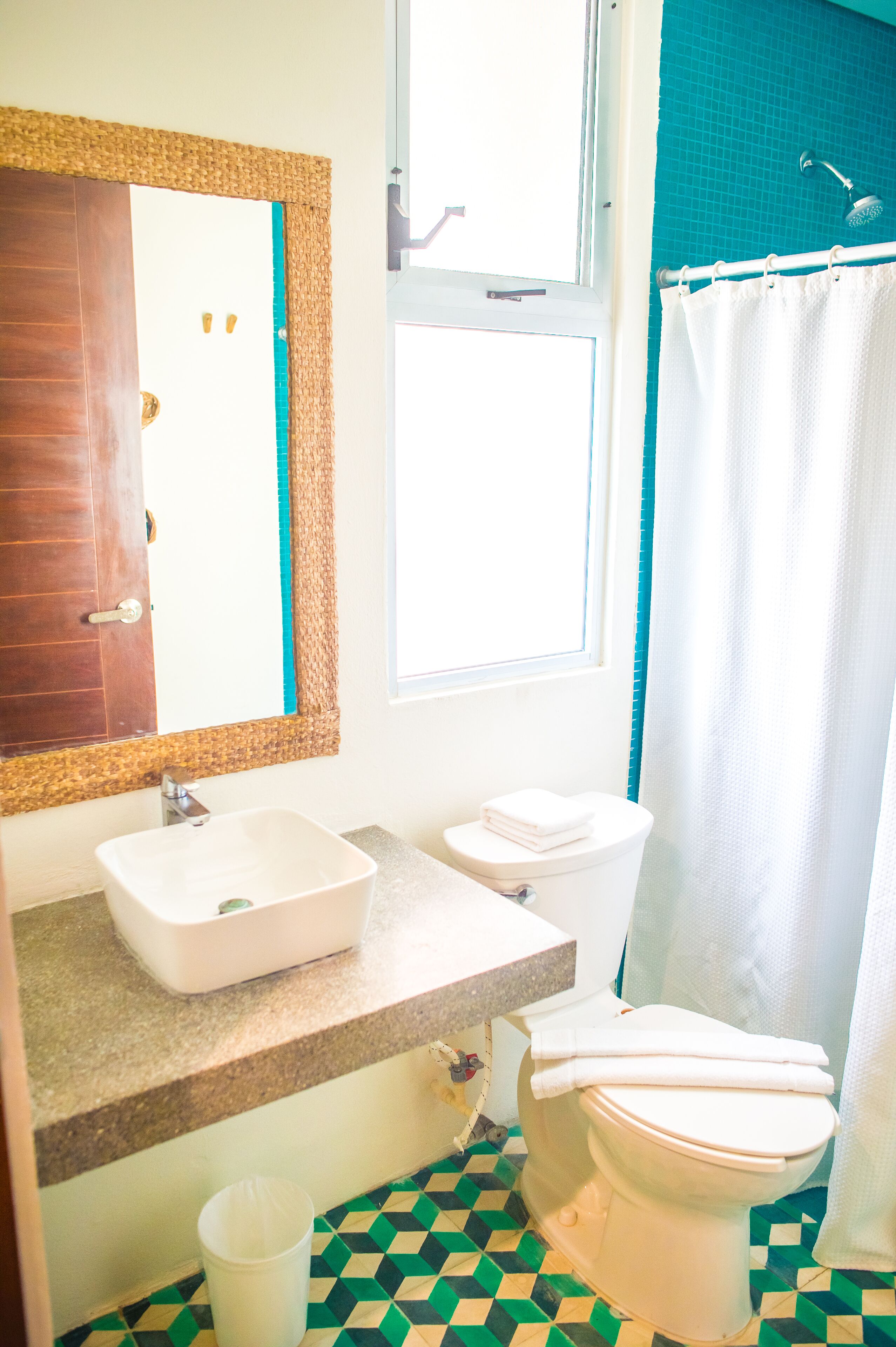 A bathroom with a sink, toilet, and shower curtain.
