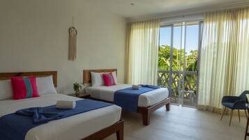 A hotel room with two beds, a balcony with curtains, and a chair.