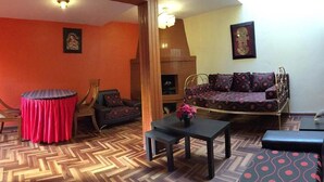 A living room with a round table, a sofa, and a bench. - Casa Riso Cusco I (Cusco)