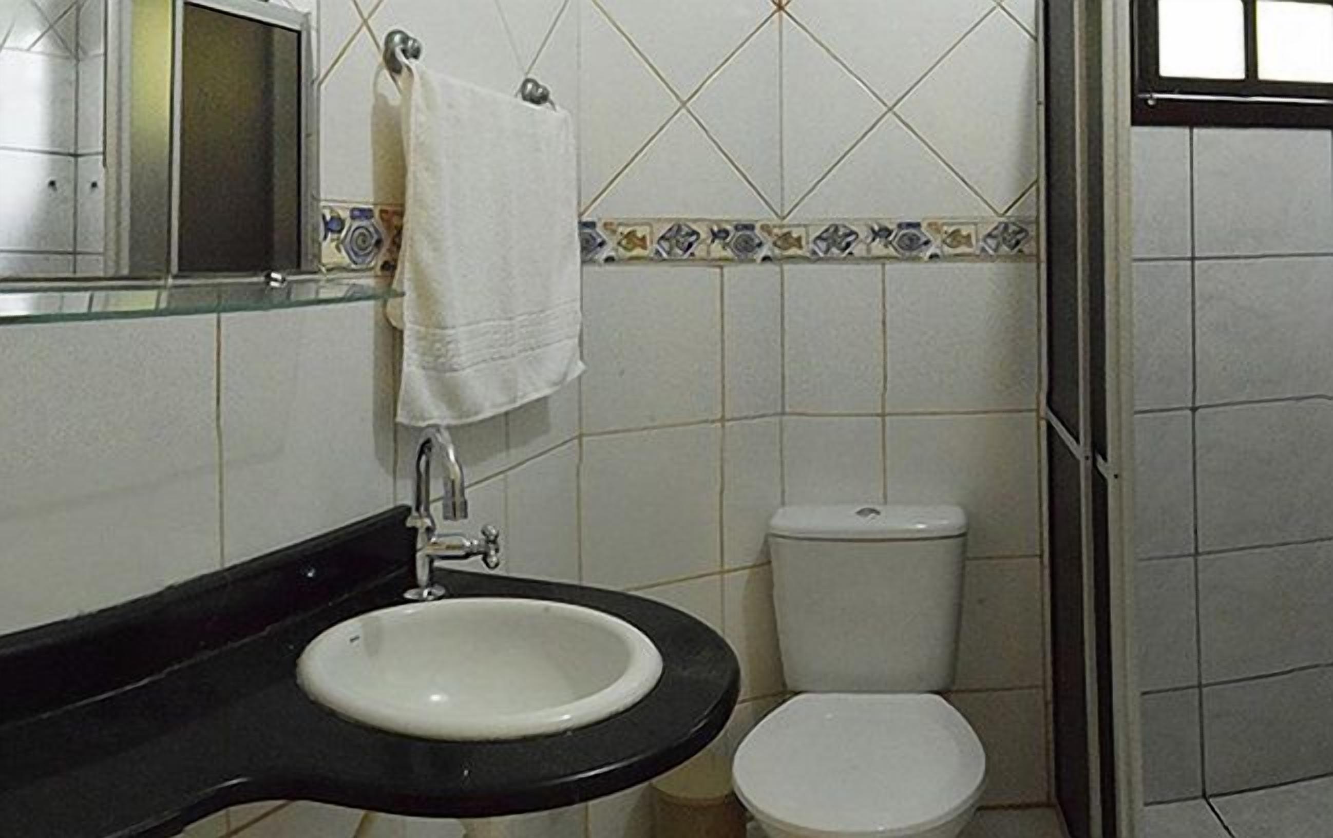 Baño con lavabo, inodoro y espejo.
