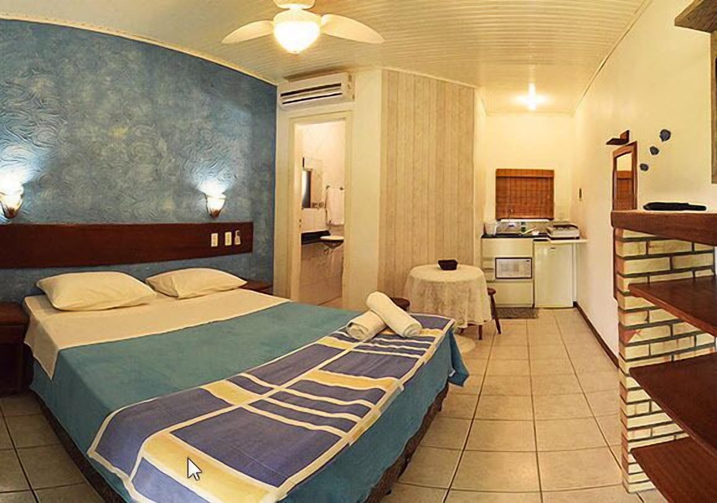 Habitació d'hotel amb llit, escriptori, cadira i taula petita.