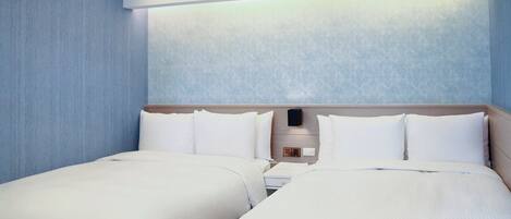 Camera d'albergo con due letti, un comodino e un pannello di controllo a parete.