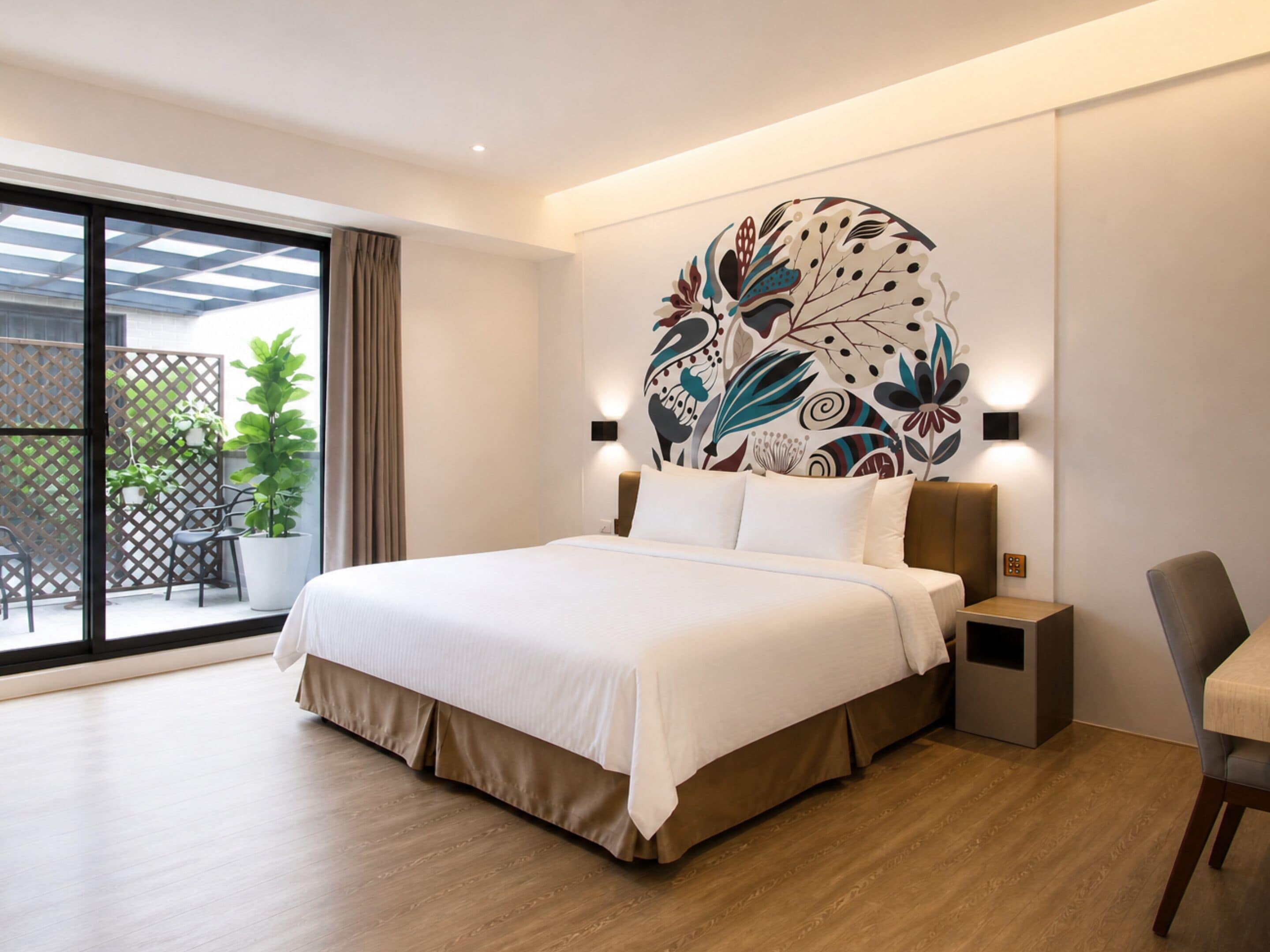 Quarto de hotel moderno com uma cama grande, vista para o exterior e um mural decorativo na parede.