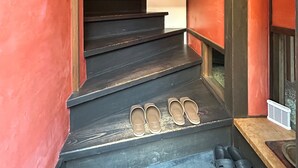 A staircase with a pair of shoes on the steps and a pair of slippers on the landing. - Kamiza-an Kamanza-tei (Kyoto)