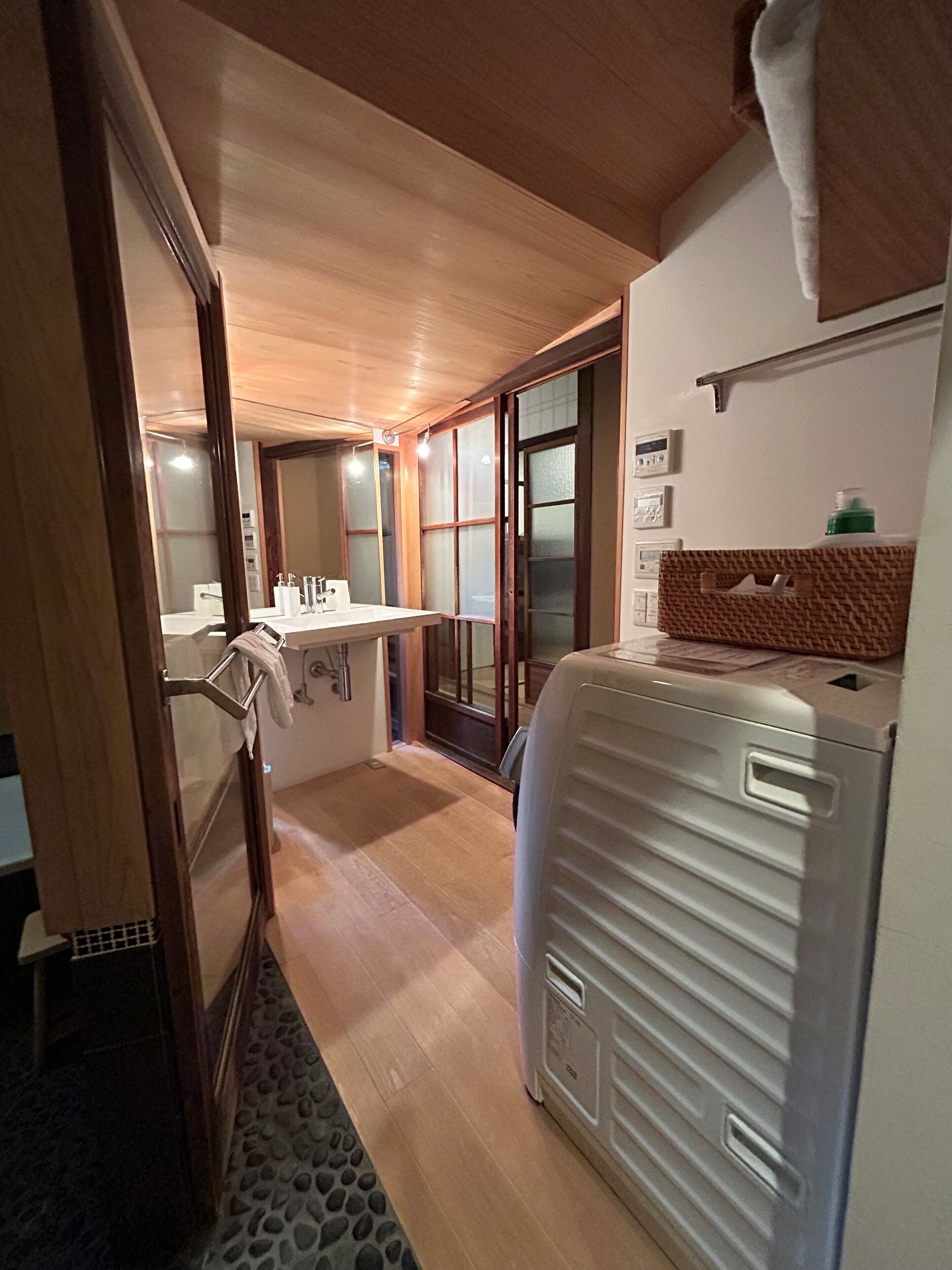 A compact bathroom with a sink, mirror, and towel rack.