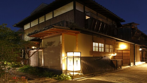 A traditional Japanese house with a wooden exterior, a tiled entrance, and a small garden area with plants and a pathway. - Shofu-an Kiyomizu-tei (Kyoto)