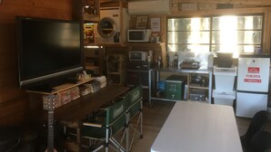 A compact kitchen with a TV, microwave, and refrigerator. - Guest House Coco Garage - Hostel (Kirishima)