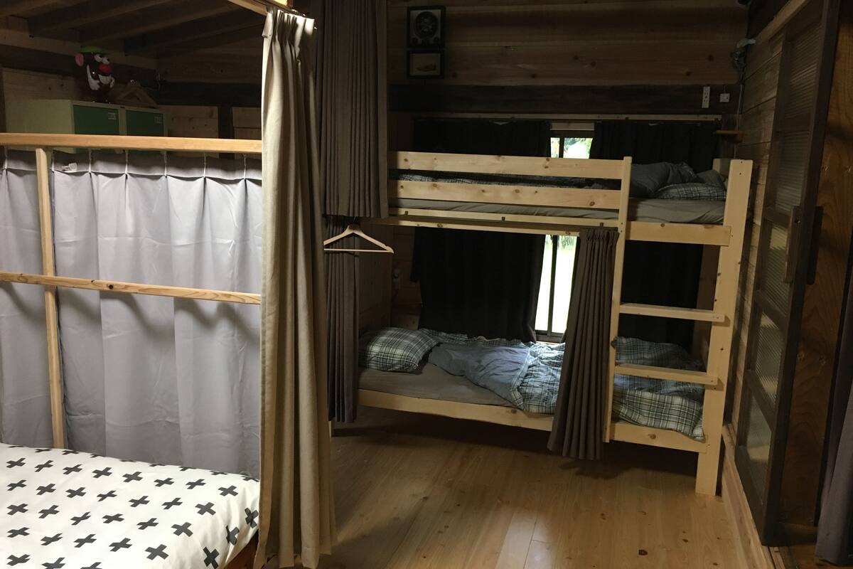 A bunk bed room with a single bed on the left and two bunk beds on the right.