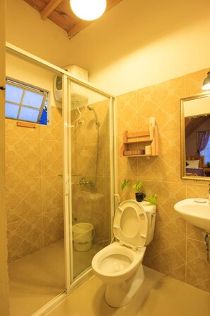 A bathroom with a glass-enclosed shower, a toilet, and a sink. - Flowersandrocks Villa (Xuan Huong - Da Lat)
